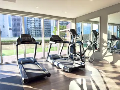 a gym with cardio equipment in a room with windows at Sleek 1BR Apt with Pool Gym by Dubai Canal, Dubai Mall & Business Bay in Dubai