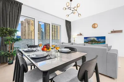 a dining table and chairs in a living room at Relaxing 1BR in Dubai With Access to Pool, Gym & Parking in Dubai