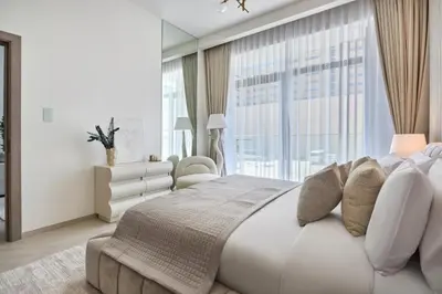 a white bedroom with a large bed and a large window at Chic-1BROxford Terrace 2 Luxuriously Furnished in Dubai