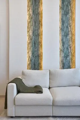 a white couch in a room with two tall columns at Chic-1BROxford Terrace 2 Luxuriously Furnished in Dubai
