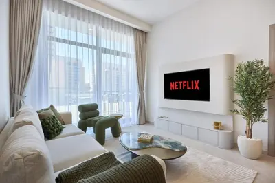 a living room with a couch and a tv at Chic-1BROxford Terrace 2 Luxuriously Furnished in Dubai