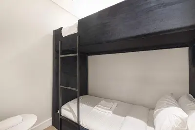 a bedroom with a bunk bed with white sheets at Luxury 4BR Prime Downtown Stay in Dubai