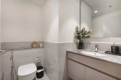 a bathroom with a toilet and a sink and a mirror at Luxury 4BR Prime Downtown Stay in Dubai