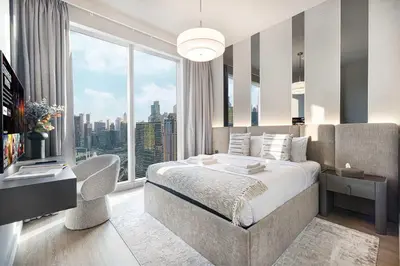 a bedroom with a large bed and a large window at Luxury 4BR Prime Downtown Stay in Dubai