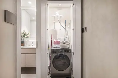 a washer and dryer in a room with a kitchen at Luxury 4BR Prime Downtown Stay in Dubai