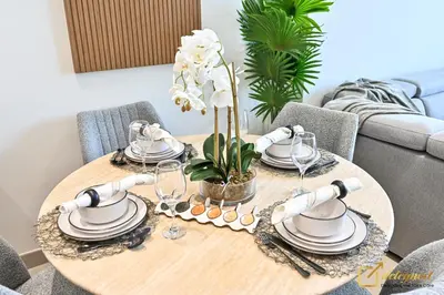 a dining room table with plates and glasses on it at Stunning 1BR in JVC Binghatti Amber by Deleguest in Dubai