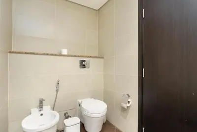 a bathroom with a toilet and a sink at Burj & Sea View King 2 Bedroom Apartment In Anantara Resort in Dubai