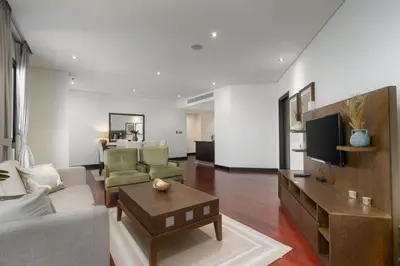 a living room with a couch and a tv at Burj & Sea View King 2 Bedroom Apartment In Anantara Resort in Dubai