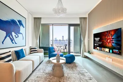 a living room with a couch and a tv at Vibrant Luxe Burj Khalifa Views-Dubai Mall Access by Maxx Value Homes in Dubai
