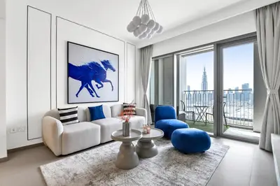 a living room with a white couch and blue chairs at Vibrant Luxe Burj Khalifa Views-Dubai Mall Access by Maxx Value Homes in Dubai