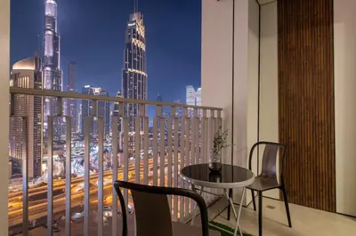a balcony with a table and chairs and a city skyline at Vibrant Luxe Burj Khalifa Views-Dubai Mall Access by Maxx Value Homes in Dubai