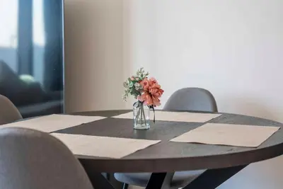 a table with a vase with flowers on it at Downtown Dubai Luxury 1 BR in BLVD Heights T1 in Dubai