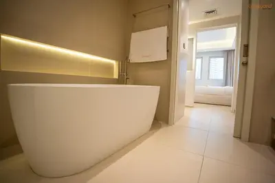 a bathroom with a large white tub in a room at Bnbeyond's Luxury Vibe & Burj View in Dubai