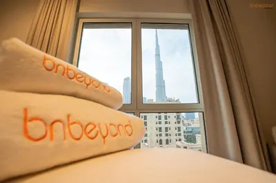 a bed with a window with a view of a city at Bnbeyond's Luxury Vibe & Burj View in Dubai