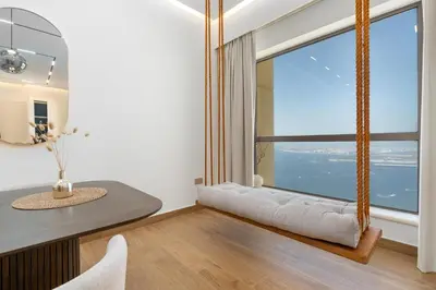 a living room with a large window with a swing at King 2 Bedroom Jumeirah Beach & Dubai Eye Views in Dubai
