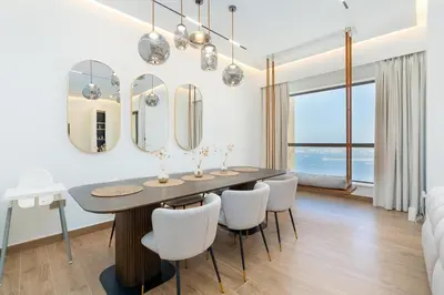 a dining room with a table and chairs and mirrors at King 2 Bedroom Jumeirah Beach & Dubai Eye Views in Dubai