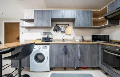 a kitchen with a sink and a washing machine at Lavish 1 bedroom in Dubai