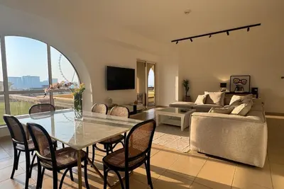 a living room with a table and chairs and a couch at Large 5-BR JBR Apartment, Perfect for Families, Easy Beach Access in Dubai