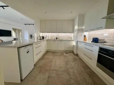 a kitchen with white cabinets and white appliances at Large 5-BR JBR Apartment, Perfect for Families, Easy Beach Access in Dubai