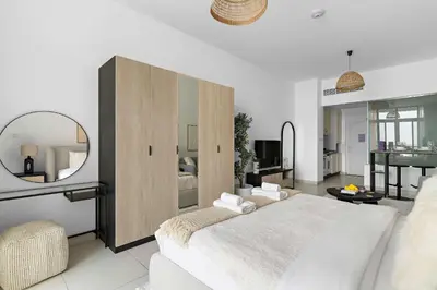 a bedroom with a large bed and a mirror at Silkhaus Seaside Studio in Palm Views West Tower in Dubai