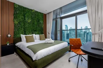 a bedroom with a green wall with a bed and a desk at Waves - Tranquil Waterfront Living 2B Retreat With Balcony in Dubai