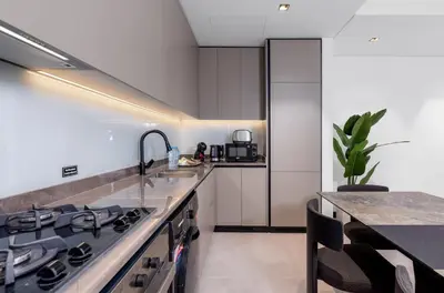 a kitchen with a sink and a stove top oven at Waves - Tranquil Waterfront Living 2B Retreat With Balcony in Dubai