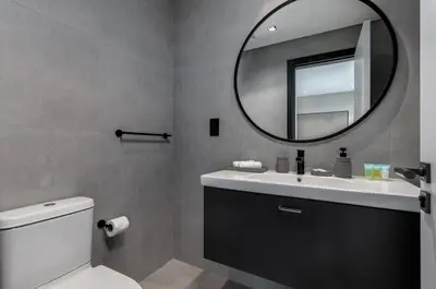 a bathroom with a white toilet and a mirror at Waves - Tranquil Waterfront Living 2B Retreat With Balcony in Dubai