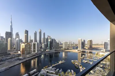 a view of a city with boats in a river at Waves - Tranquil Waterfront Living 2B Retreat With Balcony in Dubai