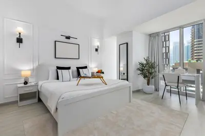 a white bedroom with a bed and a dining room at Maison Privee - Sleek Stay in Dubai Marina Famous Twisting Tower in Dubai
