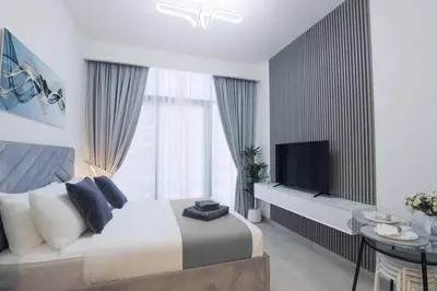 a bedroom with a large bed and a television at Azizi Riviera 42 - Meydan by Golden Casa in Dubai