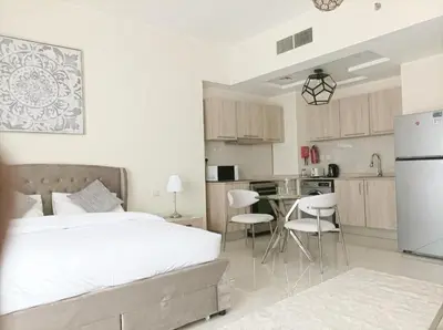 a bedroom with a white bed and a kitchen at SUPERIOR STAY HOLIDAY HOMES - Sleek & Modern Studio in Business Bay in Dubai