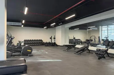 a gym with rows of exercise equipment in a room at Canal View, Partial Burj Khalifa View in Dubai