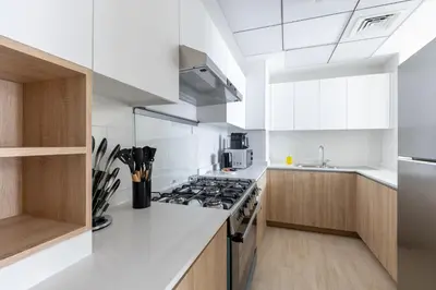 a white kitchen with a stove and a sink at Canal View, Partial Burj Khalifa View in Dubai