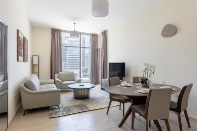 a living room with a table and chairs and a dining room at Partial Canal View, Business Bay in Dubai