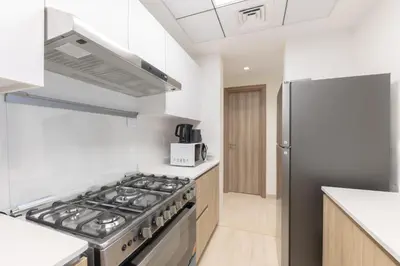 a kitchen with a stove and a refrigerator at Partial Canal View, Business Bay in Dubai