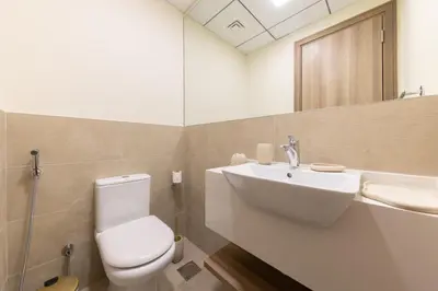 a bathroom with a white toilet and a sink at Partial Canal View, Business Bay in Dubai
