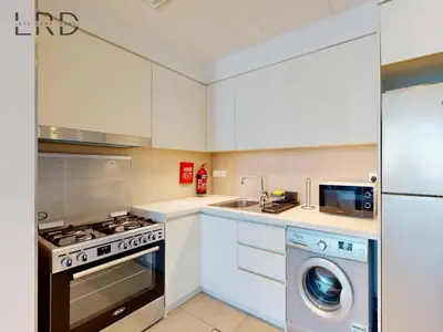 a kitchen with a washing machine and a washer at Luxurious 1BR Apartment with Creek View in Dubai