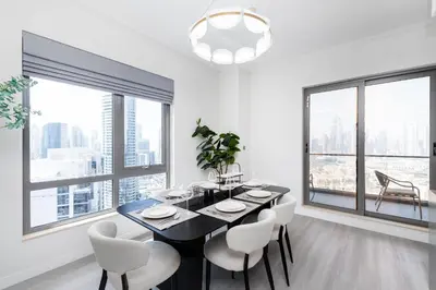 a dining room with a black table and white chairs at South Ridge 1, Downtown Dubai - Mint Stay in Dubai