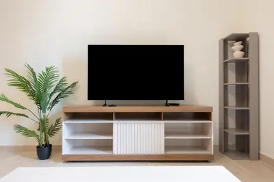 a tv on a wooden tv stand in a living room at Premium Apartment, Right Infront of Canal in Dubai