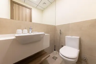 a bathroom with a white toilet and a sink at Partial Canal View, Business Bay in Dubai