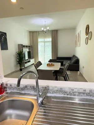 a kitchen with a sink and a living room at Bright 1BR Apartment in JVC - JLiving in Dubai