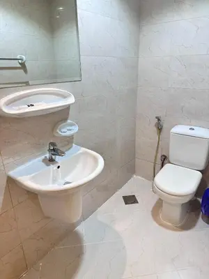 a bathroom with a sink and a toilet and a mirror at Bright 1BR Apartment in JVC - JLiving in Dubai