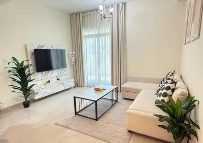 a living room with a couch and a tv at 1BR Apartment with Private Jacuzzi in JVC - JLiving in Dubai