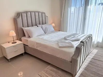 a bedroom with a large bed with a large window at 1BR Apartment with Private Jacuzzi in JVC - JLiving in Dubai