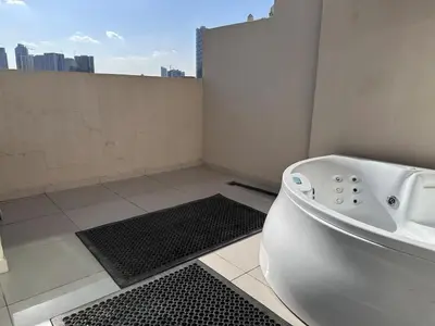 a white bath tub in a bathroom with a view at 1BR Apartment with Private Jacuzzi in JVC - JLiving in Dubai