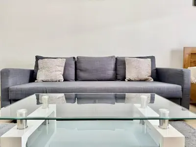 a living room with a couch and a glass coffee table at Homes2Retreat - Very Spacious Studio in the Heart of JVC in Dubai