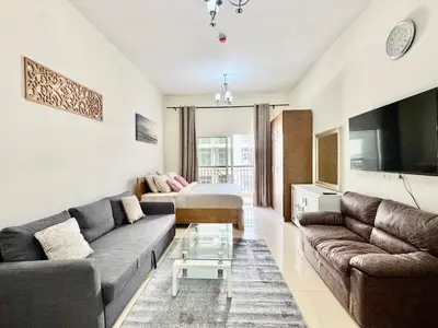 a living room with a couch and a bed at Homes2Retreat - Very Spacious Studio in the Heart of JVC in Dubai