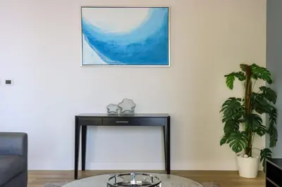 a living room with a table and a picture on the wall at Livbnb-Serene 2B with Marina and Sea View Walk to Beach in Dubai
