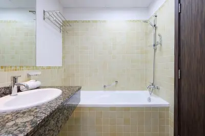 a bathroom with a sink and a tub and a mirror at Livbnb-Serene 2B with Marina and Sea View Walk to Beach in Dubai