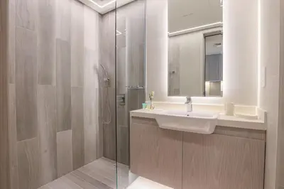 a bathroom with a sink and a shower with a mirror at Modern Studio in Condor Concept7, JVC in Dubai